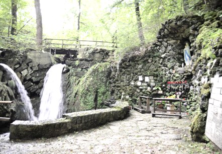 De Mariengrotte Albach heeft twee watervallen, een Mariabeeld in een rotsnis en kaarsen op een altaar. Omgeven door weelderig groen., © TI Bitburger Land De Mariengrotte Albach heeft twee watervallen, een Mariabeeld in een rotsnis en kaarsen op een altaar. Omgeven door weelderig groen., © TI Bitburger Land