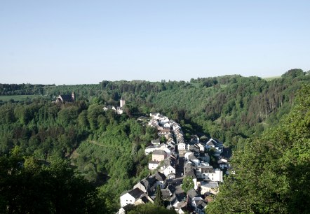 Vue panoramique de Kyllburg avec son église et ses maisons, nichée dans des forêts et des collines verdoyantes sous un ciel dégagé., © TI Bitburger Land Vue panoramique de Kyllburg avec son église et ses maisons, nichée dans des forêts et des collines verdoyantes sous un ciel dégagé., © TI Bitburger Land