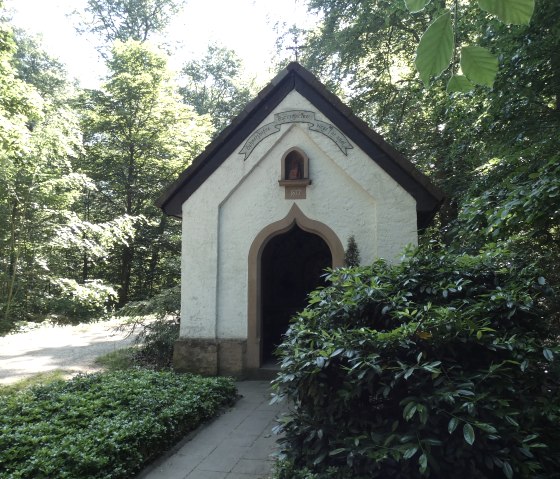 Petite chapelle dans la for&ecirc;t de Speicherer, entour&eacute;e d'une &eacute;paisse verdure. Un petit chemin m&egrave;ne &agrave; la porte d'entr&eacute;e, entour&eacute;e d'arbres et d'arbustes., &copy; TI Bitburger Land