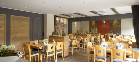 A modern restaurant with wooden tables and chairs. The cozy atmosphere is accentuated by soft lighting and decorative elements.