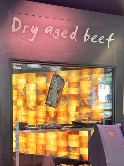 Une étagère avec du bœuf séché. En arrière-plan, un mur aux teintes chaleureuses met en valeur la viande.