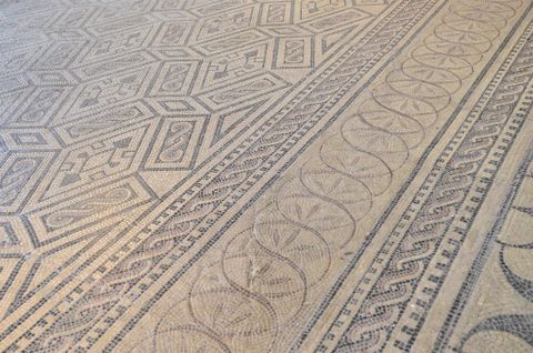 An artistic mosaic with geometric patterns and wavy designs. The color scheme is subtle and harmonious.