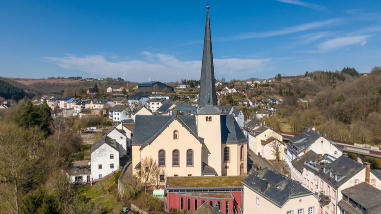 Aerial view of Waxweiler with the church in the center and surrounding houses.