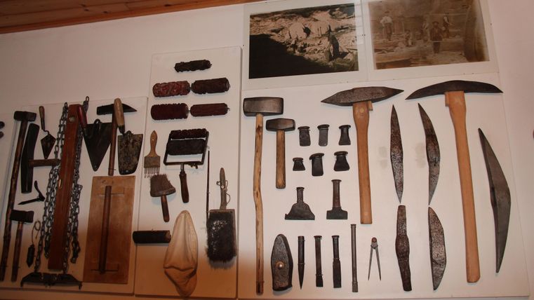 A collection of tools and equipment on a wall. The items are carefully arranged and showcase various historical tools.