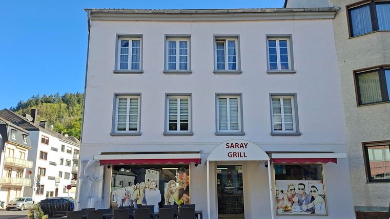 A restaurant called "Saray Grill" with an inviting exterior facade.
In front of the building, there are tables and chairs for guests to sit outside.