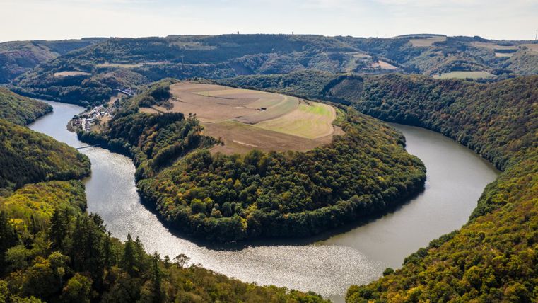 Aerial view of a river bend in a wooded landscape with fields.