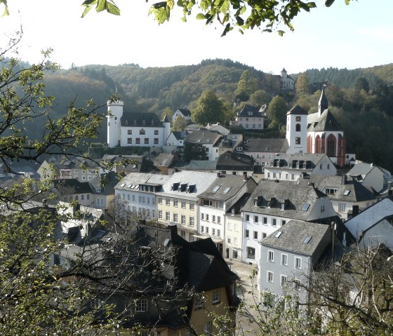 Panoramablick auf Neuerburg mit historischen Geb&auml;uden, einer Kirche und bewaldeten H&uuml;geln im Hintergrund., &copy; Christian Calonec-Rauchfuss, Felsenland S&uuml;deifel Tourismus GmbH