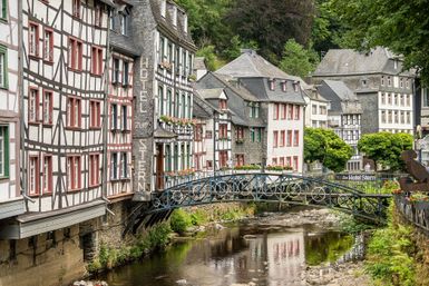 Alte Fachwerkhäuser stehen an einem kleinen Fluss