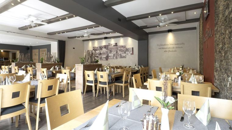 A modern restaurant with bright wooden furniture and stylish decor.
Tables are lovingly set, creating an inviting atmosphere.