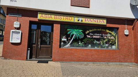 Un bistro asiatique nommé "Panda". Les fenêtres sont décorées avec un motif de palmiers et il y a un numéro de téléphone pour les commandes.