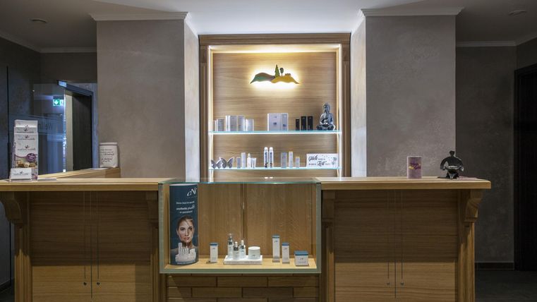 A reception desk with various skincare products in a stylish setting. The lighting creates a cozy atmosphere.
