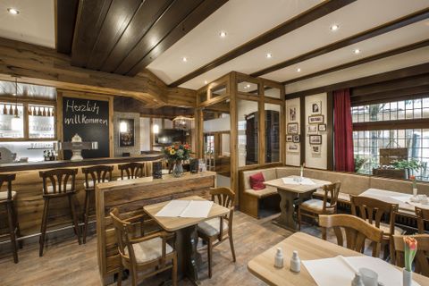 A cozy restaurant with wooden paneling and warm light.
Tables and chairs invite you to linger.