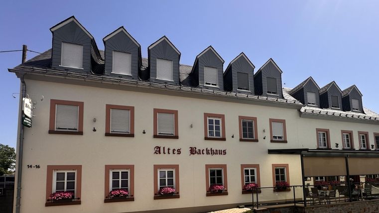 Een historisch gebouw met de naam "Altes Bräuhaus". Het heeft meerdere ramen en een uitnodigende sfeer.