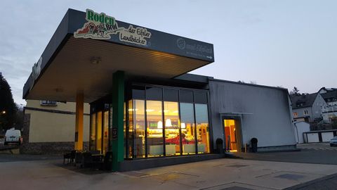 Ein modernes Restaurant mit großen Fenstern und einem einladenden Eingang. Die Fassade ist hell erleuchtet und wirkt freundlich.