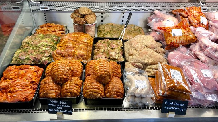 Fresh meat products in a butcher shop. Various types of meat and marinated meat are arranged on the counter.