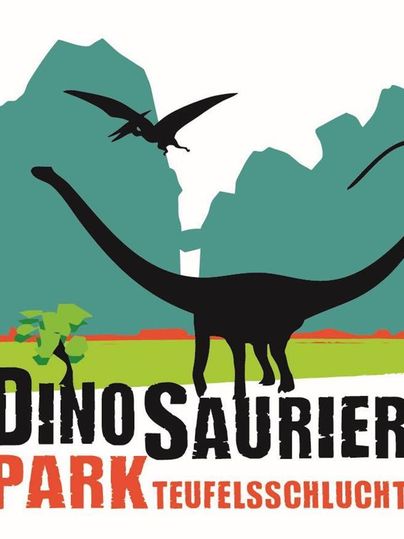 Ein Logo des Dinosaurierparks Teufelsschlucht. Es zeigt einen langen Dinosaurier und einen fliegenden Pterosaurier vor einer Berglandschaft.