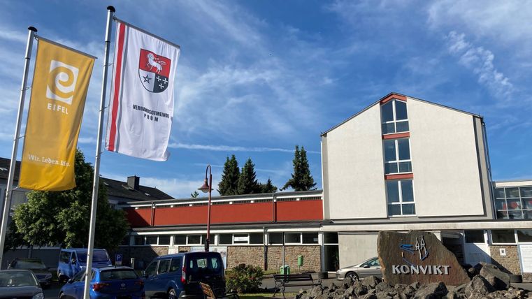 A modern building with flags in the foreground. The inscription "KONVIKT" is clearly visible.