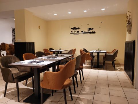 A cozy restaurant with elegant tables and chairs.
On the wall, there is a decorative wall design featuring animals.