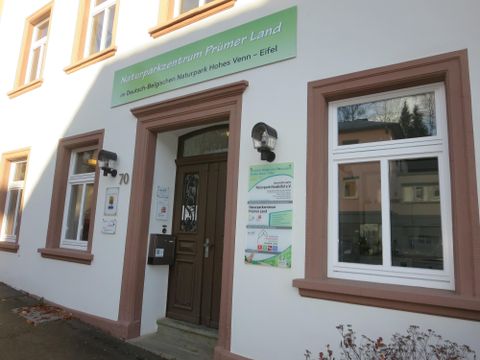 Das Bild zeigt das Gebäude des Naturzentrum Human Land mit einer einladenden Eingangstür. Über der Tür befindet sich ein Schild mit dem Namen der Einrichtung.