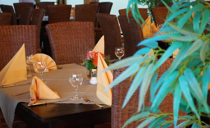 An elegant restaurant with beautifully set tables. The decor is cozy and carefully decorated.