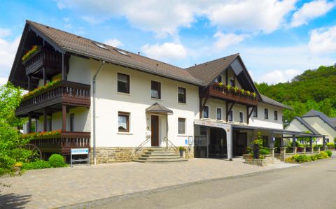 Ein ansprechendes Gebäude mit zwei Etagen und Balkonen. Die Umgebung ist grün und einladend, ideal für Erholung.
