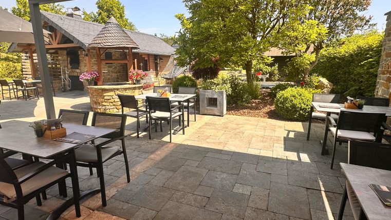 An inviting terrace with tables and chairs.
Surrounded by green plants and a cozy atmosphere.
