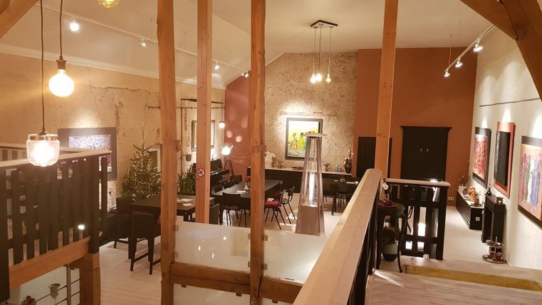 A stylish, modern living room with high ceilings and wooden details. The space is well-lit and offers a cozy atmosphere.