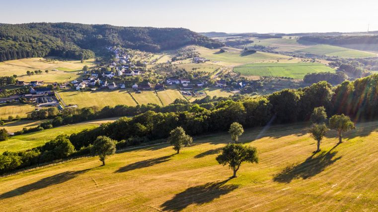 Landscape in the Enz valley with fields, trees and a village in the background.