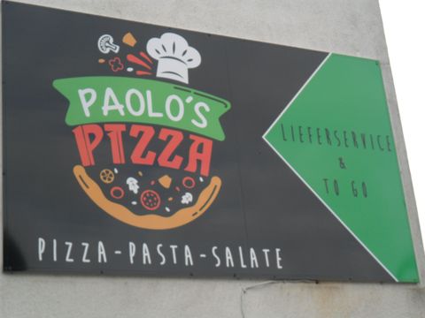 Ein Schild von "Paolo's Pizza" mit dem Angebot von Pizza, Pasta und Salaten. Es wird auch Lieferdienst und „to go“ angeboten.