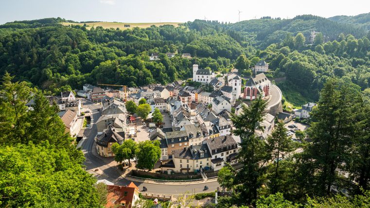 Une ville pittoresque entourée de collines verdoyantes. Les petites maisons forment une belle ligne sinueuse le long de la route.