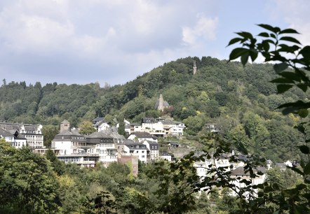 Panoramisch uitzicht op Kyllburg met huizen en een kerk op een beboste heuvel onder een blauwe lucht., &copy; TI Bitburger Land