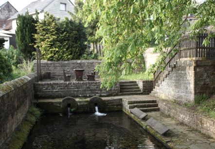 Ancien lavoir avec bassin, murs de pierre et escaliers, entour&eacute; de v&eacute;g&eacute;tation verte et d'arbres., &copy; Monika Bach