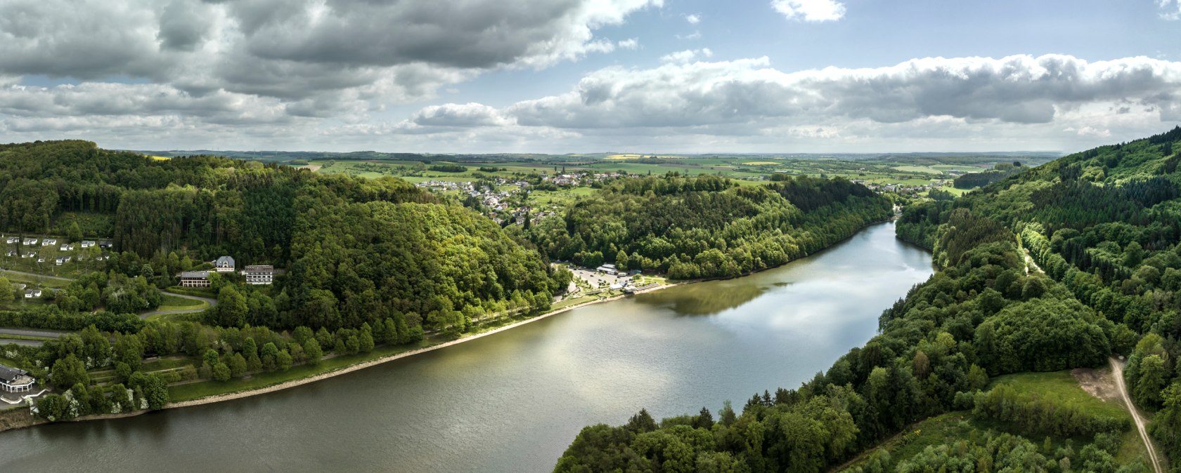 Vue a&eacute;rienne du lac de barrage de Bitburg &agrave; Biersdorf am See, entour&eacute; de for&ecirc;ts et de collines verdoyantes. Le ciel est en partie nuageux et en partie ensoleill&eacute;., &copy; Eifel-Tourismus GmbH, Dominik Ketz