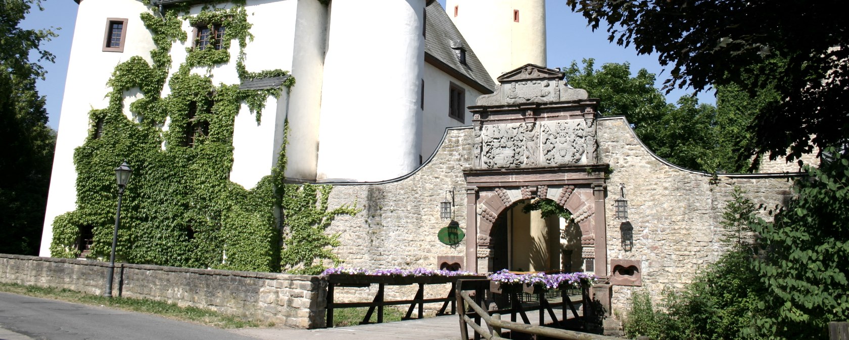 Ch&acirc;teau de Rittersdorf avec deux tours rondes et une haute tour jaune. Un arc de porte avec des d&eacute;corations m&egrave;ne au ch&acirc;teau. Du lierre pousse sur les murs., &copy; Frank Schaal