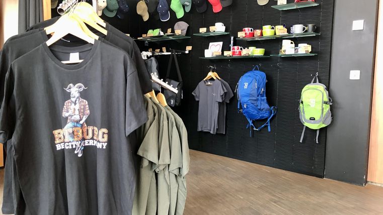 A sales area with T-shirts, caps, and backpacks. The atmosphere is modern and inviting.
