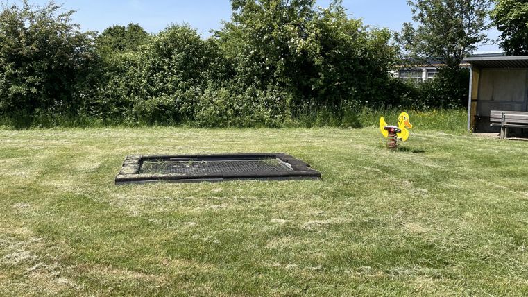 Trampoline embedded in the grass