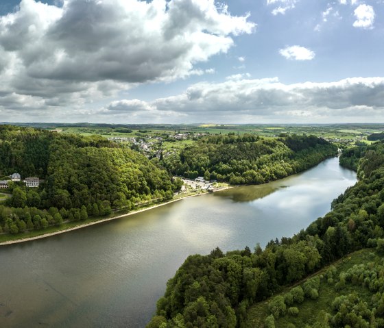 Luftaufnahme des Stausees Bitburg in Biersdorf am See, umgeben von gr&uuml;nen W&auml;ldern und H&uuml;geln unter bew&ouml;lktem Himmel., &copy; Eifel Tourismus GmbH, Dominik Ketz