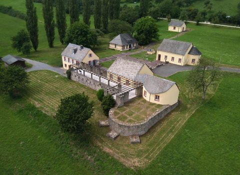 A picturesque landscape with several charming buildings. Surrounded by green grass and trees, the scenery offers a tranquil atmosphere.