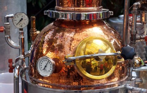 A copper distillery with a shiny surface and precise measuring instruments. It is a central element of the distillation process.