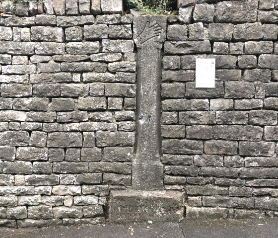 Een oude stenen muur met een kruisweg en een informatiebord. De statie toont een reli&euml;f van een hand. Eronder staat een inscriptie., &copy; TI Bitburger Land